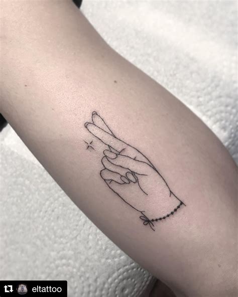 small fingers crossed tattoo